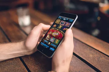 A cheerful woman in traditional clothing using her smartphone during a festive moment, showing how easily the SOYL777 app fits into everyday life.