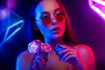 A woman smiling by bright slot machines showing lucky symbols, showcasing the exciting slot offerings at SOYL777.